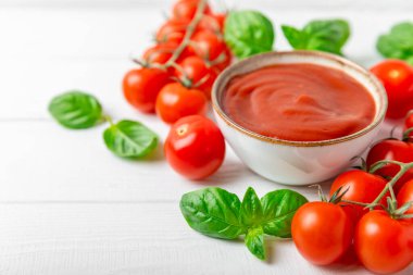 Domates ezmesi, sos, kâsede ketçap ve ahşap kaplamalı taze fesleğen yapraklı kiraz domatesleri. Vitaminler ve detoks diyeti. Sebze ve vejetaryen yemekleri. Mesaj için yer var. Boşluğu kopyala.