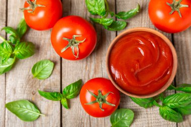 Domates ezmesi, sos, kâsede ketçap ve ahşap kaplamalı taze fesleğen yapraklı kiraz domatesleri. Vitaminler ve detoks diyeti. Sebze ve vejetaryen yemekleri. Mesaj için yer var. Boşluğu kopyala.