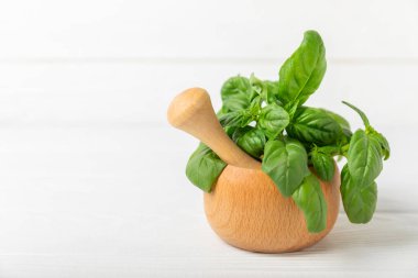 Ahşap kaplamalı havanda taze yeşil fesleğen. Organik baharatlar ve bitkiler. Vejetaryen. Taze mutfak bitkileri. Fesleğen taze fesleğen havan ve kabuklu pesto 'ya dönüştürülüyor. Boşluğu kopyala. Metin için yer