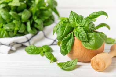 Ahşap kaplamalı havanda taze yeşil fesleğen. Organik baharatlar ve bitkiler. Vejetaryen. Taze mutfak bitkileri. Fesleğen taze fesleğen havan ve kabuklu pesto 'ya dönüştürülüyor. Boşluğu kopyala. Metin için yer