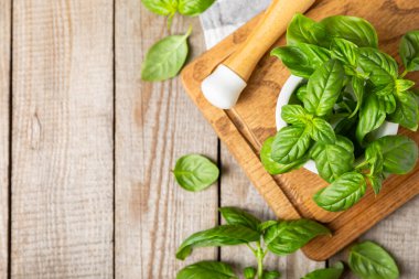 Ahşap kaplamalı havanda taze yeşil fesleğen. Organik baharatlar ve bitkiler. Vejetaryen. Taze mutfak bitkileri. Fesleğen taze fesleğen havan ve kabuklu pesto 'ya dönüştürülüyor. Boşluğu kopyala. Metin için yer