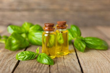 Ahşap kaplamalı fesleğen yağı. Fesleğen yağı ve taze yapraklar. Aromaterapi. Aroma yağı. Şifalı bitkiler. Alternatif tıp. Mesaj için yer. Boşluğu kopyala.