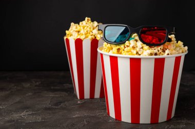 Kova içinde lezzetli patlamış mısır ve sinema biletli soğuk kola içecekler, renkli arka planda üç boyutlu gözlük. Sinema konsepti. Film izliyorum. Mesaj için yer var. Boşluğu kopyala