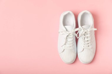 Beyaz ayakkabılar, parlak renkli arka planda spor ayakkabılar. Tek cinsiyetli spor ayakkabıları. Üst Manzara. Mesaj için yer var. Uzayı kopyala. Güzel spor ayakkabılar. Moda ayakkabılar