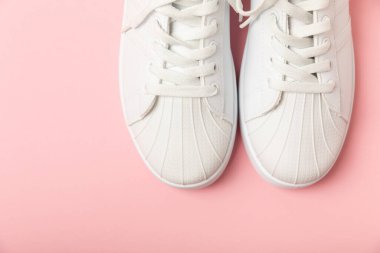 Beyaz ayakkabılar, parlak renkli arka planda spor ayakkabılar. Tek cinsiyetli spor ayakkabıları. Üst Manzara. Mesaj için yer var. Uzayı kopyala. Güzel spor ayakkabılar. Moda ayakkabılar