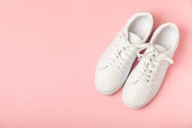 Beyaz ayakkabılar, parlak renkli arka planda spor ayakkabılar. Tek cinsiyetli spor ayakkabıları. Üst Manzara. Mesaj için yer var. Uzayı kopyala. Güzel spor ayakkabılar. Moda ayakkabılar