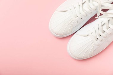 Beyaz ayakkabılar, parlak renkli arka planda spor ayakkabılar. Tek cinsiyetli spor ayakkabıları. Üst Manzara. Mesaj için yer var. Uzayı kopyala. Güzel spor ayakkabılar. Moda ayakkabılar