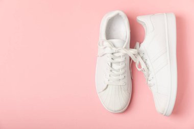 Beyaz ayakkabılar, parlak renkli arka planda spor ayakkabılar. Tek cinsiyetli spor ayakkabıları. Üst Manzara. Mesaj için yer var. Uzayı kopyala. Güzel spor ayakkabılar. Moda ayakkabılar