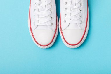 Beyaz ayakkabılar, parlak renkli arka planda spor ayakkabılar. Tek cinsiyetli spor ayakkabıları. Üst Manzara. Mesaj için yer var. Uzayı kopyala. Güzel spor ayakkabılar. Moda ayakkabılar