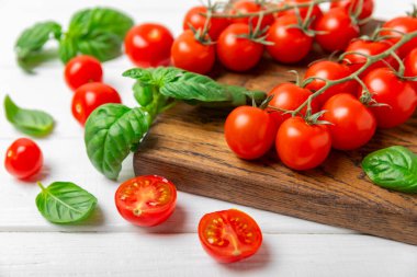 Taze vişneli domates ve dokulu taze yeşil fesleğen. Domates sosu. Vejetaryen. Salata için malzemeler. Organik yiyecekler. Mesaj için yer. Boşluğu kopyala.