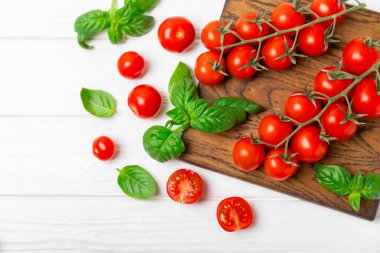 Taze vişneli domates ve dokulu taze yeşil fesleğen. Domates sosu. Vejetaryen. Salata için malzemeler. Organik yiyecekler. Mesaj için yer. Boşluğu kopyala.