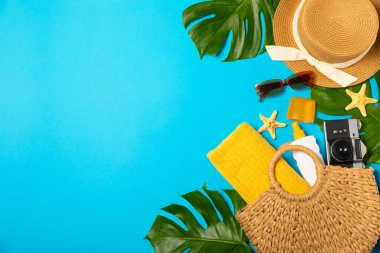 Plaj aksesuarları. Şapkalı plaj çantası, plaj havlusu, güneş gözlüğü, parlak renkli arka planda saç kremi ve sandaletler. Tropik tatil konsepti. Yaz haftasonu. Düz yatıyordu. Mesaj için yer var. Boşluğu kopyala