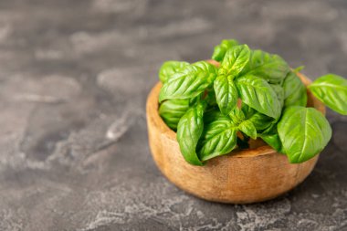 Ahşap kaplamalı yeşil fesleğen yaprakları. Mutfak otları, baharatlar. Taze yeşil organik fesleğen. Vejetaryen. Salata için yeşillik. Mesaj için yer. Boşluğu kopyala.