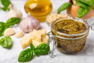 Pesto. Ahşap kaplamalı İtalyan fesleğen sosu. Pesto sosu içeriği: taze fesleğen, çam fıstığı, parmesan peyniri ve zeytinyağı. Metin için boşluk. Boşluğu kopyala.