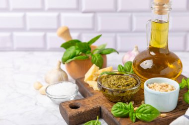 Pesto. Ahşap kaplamalı İtalyan fesleğen sosu. Pesto sosu içeriği: taze fesleğen, çam fıstığı, parmesan peyniri ve zeytinyağı. Metin için boşluk. Boşluğu kopyala.