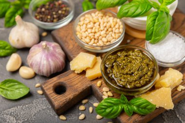 Pesto. Ahşap kaplamalı İtalyan fesleğen sosu. Pesto sosu içeriği: taze fesleğen, çam fıstığı, parmesan peyniri ve zeytinyağı. Metin için boşluk. Boşluğu kopyala.