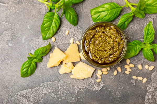 Pesto. Ahşap kaplamalı İtalyan fesleğen sosu. Pesto sosu içeriği: taze fesleğen, çam fıstığı, parmesan peyniri ve zeytinyağı. Metin için boşluk. Boşluğu kopyala.
