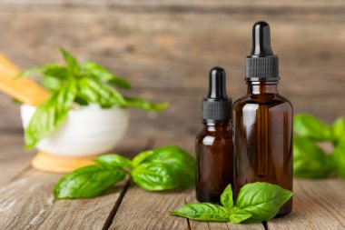 Ahşap kaplamalı fesleğen yağı. Fesleğen yağı ve taze yapraklar. Aromaterapi. Aroma yağı. Şifalı bitkiler. Alternatif tıp. Mesaj için yer. Boşluğu kopyala.