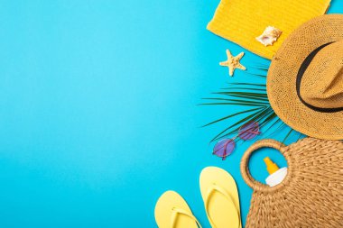 Plaj aksesuarları. Şapkalı plaj çantası, plaj havlusu, güneş gözlüğü, parlak renkli arka planda saç kremi ve sandaletler. Tropik tatil konsepti. Yaz haftasonu. Düz yatıyordu. Mesaj için yer var. Boşluğu kopyala