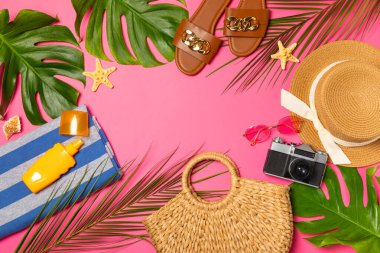 Plaj aksesuarları. Şapkalı plaj çantası, plaj havlusu, güneş gözlüğü, parlak renkli arka planda saç kremi ve sandaletler. Tropik tatil konsepti. Yaz haftasonu. Düz yatıyordu. Mesaj için yer var. Boşluğu kopyala
