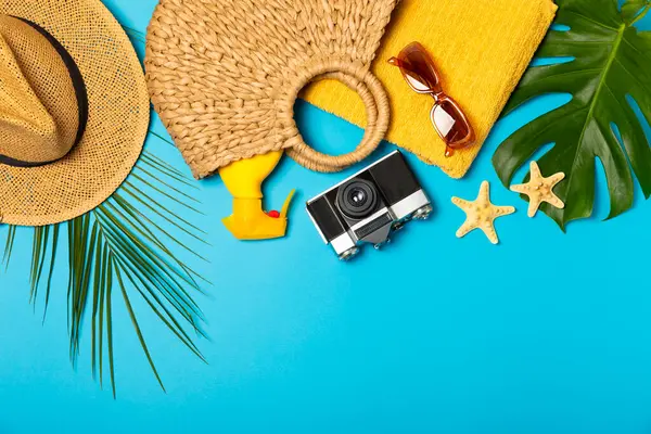 Plaj aksesuarları. Şapkalı plaj çantası, plaj havlusu, güneş gözlüğü, parlak renkli arka planda saç kremi ve sandaletler. Tropik tatil konsepti. Yaz haftasonu. Düz yatıyordu. Mesaj için yer var. Boşluğu kopyala