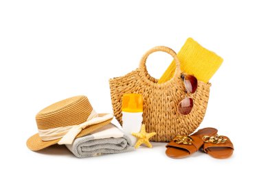 Plaj aksesuarları. Şapkalı plaj çantası, plaj havlusu, güneş gözlüğü, krem ve beyaz arka planda izole edilmiş sandaletler. Tropik tatil konsepti. Yaz haftasonu. Düz yatıyordu. Mesaj için yer var. Boşluğu kopyala