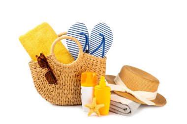 Plaj aksesuarları. Şapkalı plaj çantası, plaj havlusu, güneş gözlüğü, krem ve beyaz arka planda izole edilmiş sandaletler. Tropik tatil konsepti. Yaz haftasonu. Düz yatıyordu. Mesaj için yer var. Boşluğu kopyala