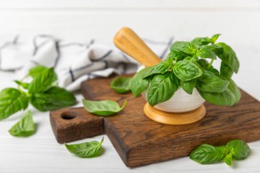 Ahşap kaplamalı havanda taze yeşil fesleğen. Organik baharatlar ve bitkiler. Vejetaryen. Taze mutfak bitkileri. Fesleğen taze fesleğen havan ve kabuklu pesto 'ya dönüştürülüyor. Boşluğu kopyala. Metin için yer