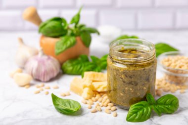 Pesto. Ahşap kaplamalı İtalyan fesleğen sosu. Pesto sosu içeriği: taze fesleğen, çam fıstığı, parmesan peyniri ve zeytinyağı. Metin için boşluk. Boşluğu kopyala.