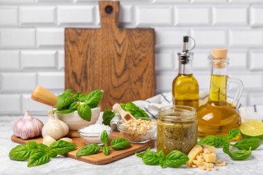 Pesto. Ahşap kaplamalı İtalyan fesleğen sosu. Pesto sosu içeriği: taze fesleğen, çam fıstığı, parmesan peyniri ve zeytinyağı. Metin için boşluk. Boşluğu kopyala.
