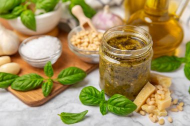 Pesto. Ahşap kaplamalı İtalyan fesleğen sosu. Pesto sosu içeriği: taze fesleğen, çam fıstığı, parmesan peyniri ve zeytinyağı. Metin için boşluk. Boşluğu kopyala.