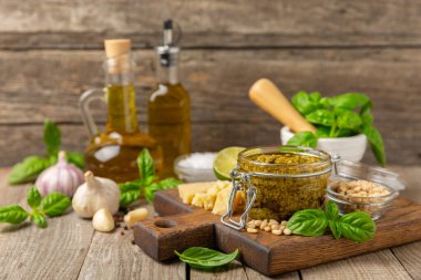 Pesto. Ahşap kaplamalı İtalyan fesleğen sosu. Pesto sosu içeriği: taze fesleğen, çam fıstığı, parmesan peyniri ve zeytinyağı. Metin için boşluk. Boşluğu kopyala.