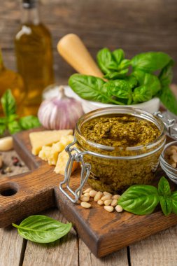 Pesto. Ahşap kaplamalı İtalyan fesleğen sosu. Pesto sosu içeriği: taze fesleğen, çam fıstığı, parmesan peyniri ve zeytinyağı. Metin için boşluk. Boşluğu kopyala.