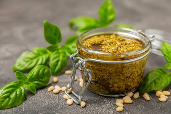 Pesto. Ahşap kaplamalı İtalyan fesleğen sosu. Pesto sosu içeriği: taze fesleğen, çam fıstığı, parmesan peyniri ve zeytinyağı. Metin için boşluk. Boşluğu kopyala.