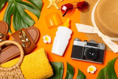 Plaj aksesuarları. Şapkalı plaj çantası, plaj havlusu, güneş gözlüğü, parlak renkli arka planda saç kremi ve sandaletler. Tropik tatil konsepti. Yaz haftasonu. Düz yatıyordu. Mesaj için yer var. Boşluğu kopyala