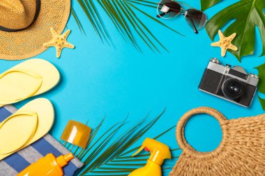 Plaj aksesuarları. Şapkalı plaj çantası, plaj havlusu, güneş gözlüğü, parlak renkli arka planda saç kremi ve sandaletler. Tropik tatil konsepti. Yaz haftasonu. Düz yatıyordu. Mesaj için yer var. Boşluğu kopyala