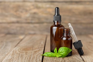 Ahşap kaplamalı fesleğen yağı. Fesleğen yağı ve taze yapraklar. Aromaterapi. Aroma yağı. Şifalı bitkiler. Alternatif tıp. Mesaj için yer. Boşluğu kopyala.