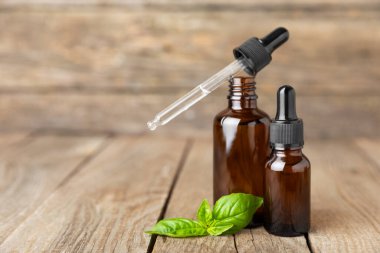 Ahşap kaplamalı fesleğen yağı. Fesleğen yağı ve taze yapraklar. Aromaterapi. Aroma yağı. Şifalı bitkiler. Alternatif tıp. Mesaj için yer. Boşluğu kopyala.