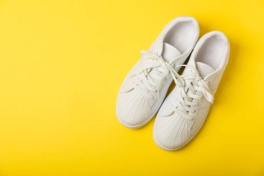 Beyaz ayakkabılar, parlak renkli arka planda spor ayakkabılar. Tek cinsiyetli spor ayakkabıları. Üst Manzara. Mesaj için yer var. Uzayı kopyala. Güzel spor ayakkabılar. Moda ayakkabılar