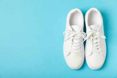 Beyaz ayakkabılar, parlak renkli arka planda spor ayakkabılar. Tek cinsiyetli spor ayakkabıları. Üst Manzara. Mesaj için yer var. Uzayı kopyala. Güzel spor ayakkabılar. Moda ayakkabılar