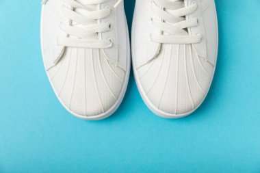 Beyaz ayakkabılar, parlak renkli arka planda spor ayakkabılar. Tek cinsiyetli spor ayakkabıları. Üst Manzara. Mesaj için yer var. Uzayı kopyala. Güzel spor ayakkabılar. Moda ayakkabılar