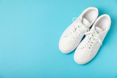 Beyaz ayakkabılar, parlak renkli arka planda spor ayakkabılar. Tek cinsiyetli spor ayakkabıları. Üst Manzara. Mesaj için yer var. Uzayı kopyala. Güzel spor ayakkabılar. Moda ayakkabılar