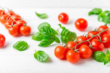 Taze vişneli domates ve dokulu taze yeşil fesleğen. Domates sosu. Vejetaryen. Salata için malzemeler. Organik yiyecekler. Mesaj için yer. Boşluğu kopyala.