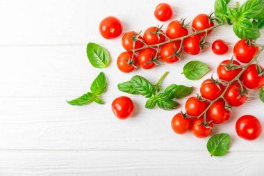 Taze vişneli domates ve dokulu taze yeşil fesleğen. Domates sosu. Vejetaryen. Salata için malzemeler. Organik yiyecekler. Mesaj için yer. Boşluğu kopyala.