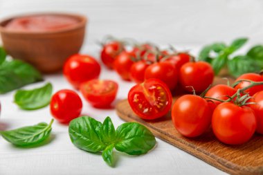 Taze vişneli domates ve dokulu taze yeşil fesleğen. Domates sosu. Vejetaryen. Salata için malzemeler. Organik yiyecekler. Mesaj için yer. Boşluğu kopyala.