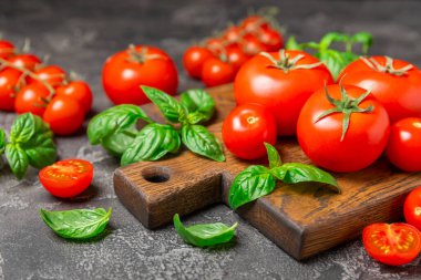 Taze vişneli domates ve dokulu taze yeşil fesleğen. Domates sosu. Vejetaryen. Salata için malzemeler. Organik yiyecekler. Mesaj için yer. Boşluğu kopyala.
