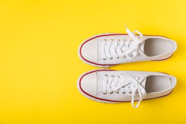 Beyaz ayakkabılar, parlak renkli arka planda spor ayakkabılar. Tek cinsiyetli spor ayakkabıları. Üst Manzara. Mesaj için yer var. Uzayı kopyala. Güzel spor ayakkabılar. Moda ayakkabılar