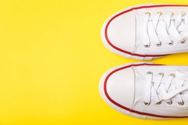 Beyaz ayakkabılar, parlak renkli arka planda spor ayakkabılar. Tek cinsiyetli spor ayakkabıları. Üst Manzara. Mesaj için yer var. Uzayı kopyala. Güzel spor ayakkabılar. Moda ayakkabılar