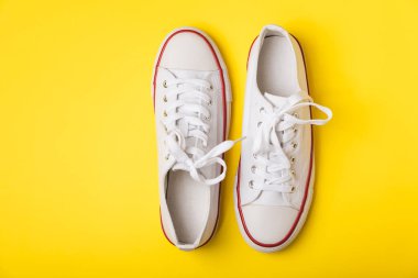 Beyaz ayakkabılar, parlak renkli arka planda spor ayakkabılar. Tek cinsiyetli spor ayakkabıları. Üst Manzara. Mesaj için yer var. Uzayı kopyala. Güzel spor ayakkabılar. Moda ayakkabılar