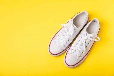 Beyaz ayakkabılar, parlak renkli arka planda spor ayakkabılar. Tek cinsiyetli spor ayakkabıları. Üst Manzara. Mesaj için yer var. Uzayı kopyala. Güzel spor ayakkabılar. Moda ayakkabılar